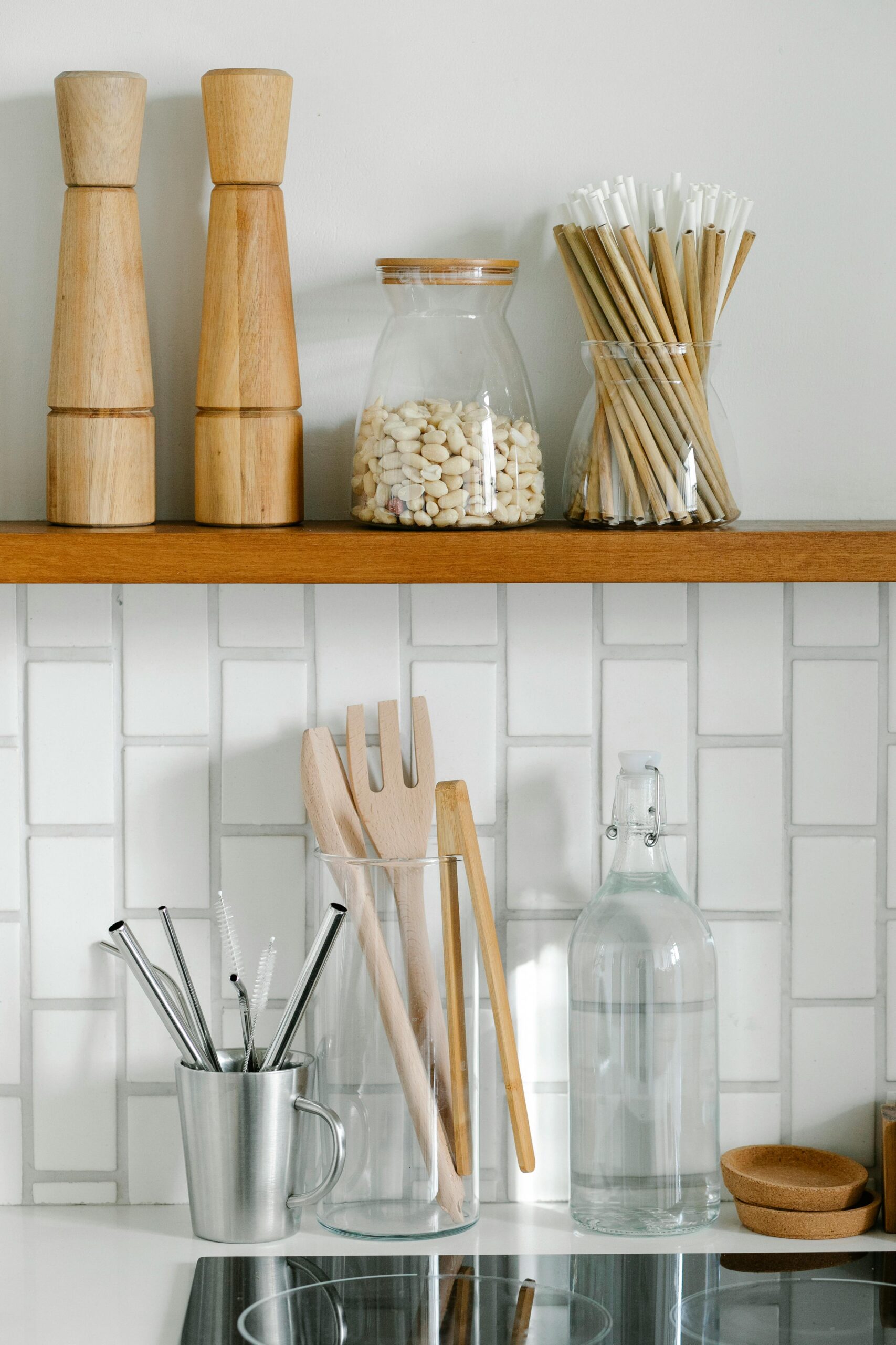 A well-organized kitchen shelf with wooden kitchenware, utensils, and storage jars.